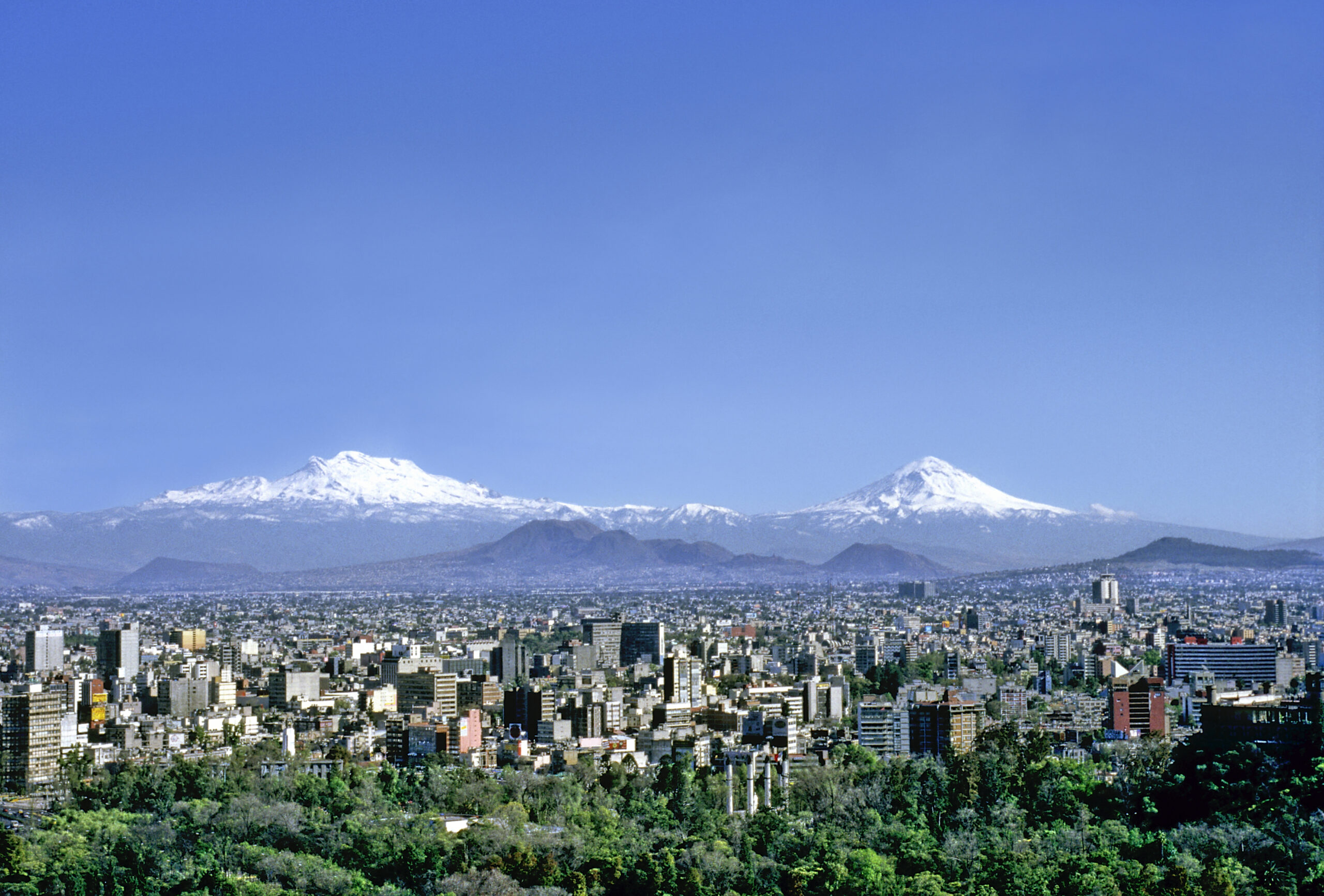 A view of the city from above with mountains in the background.